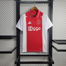 "Camisa Ajax Home (1) 2024/25 Adidas Torcedor Masculina oficial, branca com faixa vermelha central, escudo bordado e logo Adidas, versão torcedor da temporada 24/25."