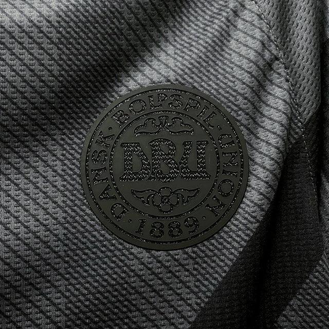 “Camisa Dinamarca Third III 2022/23 Hummel Torcedor Masculina, preta, com escudo da seleção dinamarquesa e logo Hummel em destaque, feita em tecido leve e respirável, modelo masculino com caimento confortável, ideal para jogos e uso casual.”