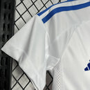 “Kit infantil Olympique Lyon 2024/25 Adidas, branco com detalhes azul e vermelho.”
