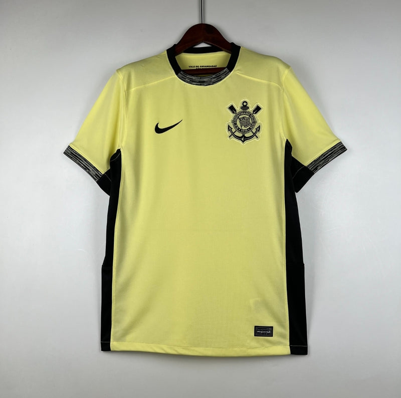 Camisa Corinthians Third III 2023/24 Nike torcedor masculina amarela, com escudo do clube bordado no peito, detalhes em preto e design inspirado na Democracia Corinthiana