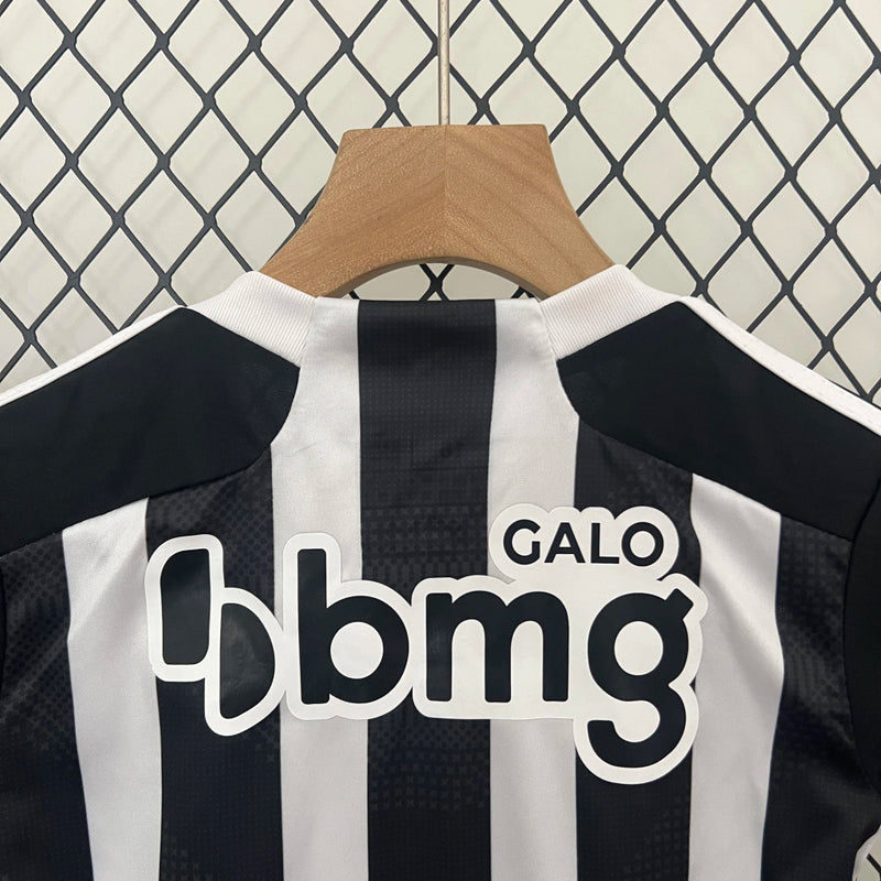 Kit Infantil Atlético Mineiro Home 2024/25 Adidas, camisa listrada preta e branca com shorts e meias, uniforme oficial para crianças torcedoras do Galo."
