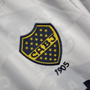 Camisa Boca Juniors Away (2) 1992/96 Olan Retrô Masculina azul escura com faixa amarela horizontal, gola polo com botões e escudo bordado clássico.
