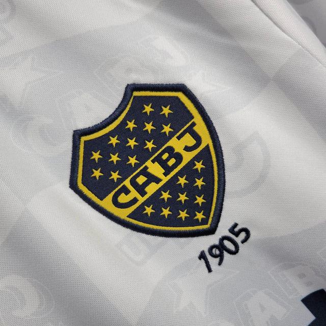 Camisa Boca Juniors Away (2) 1992/96 Olan Retrô Masculina azul escura com faixa amarela horizontal, gola polo com botões e escudo bordado clássico.
