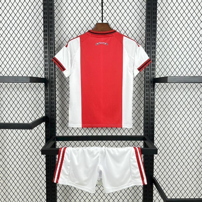 Kit Infantil Ajax Home I 2025/26 Adidas, uniforme completo com camisa e short, nas cores tradicionais do clube, ideal para treinos, jogos e momentos de lazer.