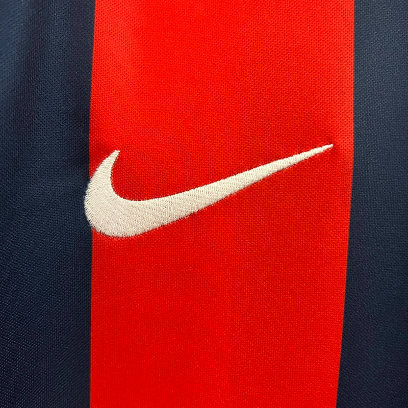 "Camisa San Lorenzo Home I 2024/25 Nike Torcedor Masculina azul com listras vermelhas, escudo estampado do clube argentino e design clássico azulgrana."