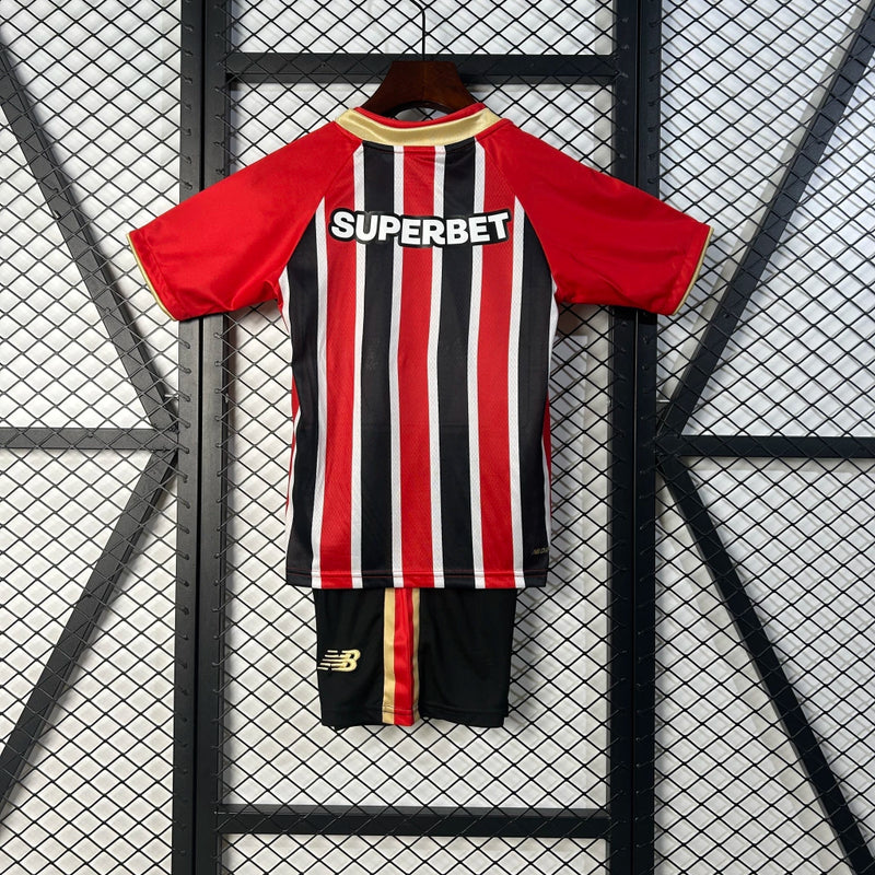 Kit Infantil São Paulo Away 2025/26 Adidas com camisa branca, detalhes em vermelho e preto, escudo do São Paulo bordado no peito, short oficial incluso, ideal para torcedores mirins, produto oficial licenciado.”