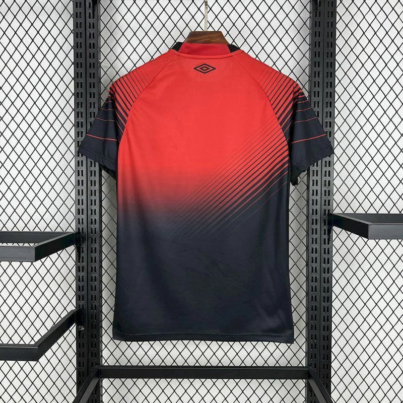 Camisa Athletico Paranaense Home (1) 2025/26 Umbro Torcedor Masculina com escudo oficial bordado e logo Umbro estampado, modelo clássico em vermelho e preto do clube paranaense.