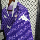 Camisa Fiorentina Home I 2023/24 Kappa Torcedor Masculina roxa com escudo bordado no peito, logo Kappa em destaque nos ombros, gola redonda moderna e tecido leve e respirável, perfeita para torcedores que valorizam estilo, conforto e tradição do clube italiano.