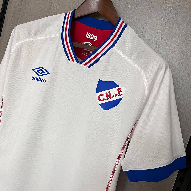 Camisa Nacional Uruguai Treino Umbro 2025/26 Torcedor Masculina Branca com escudo bordado e logo da Umbro, modelo oficial para torcedores do Club Nacional de Football.