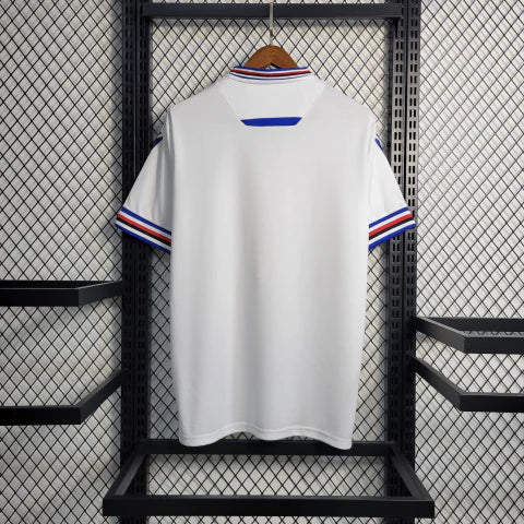 Camisa Sampdoria Away II 2022/23 Torcedor Masculina Branca com faixas azul, vermelha e preta no peito, escudo bordado e design clássico do clube italiano