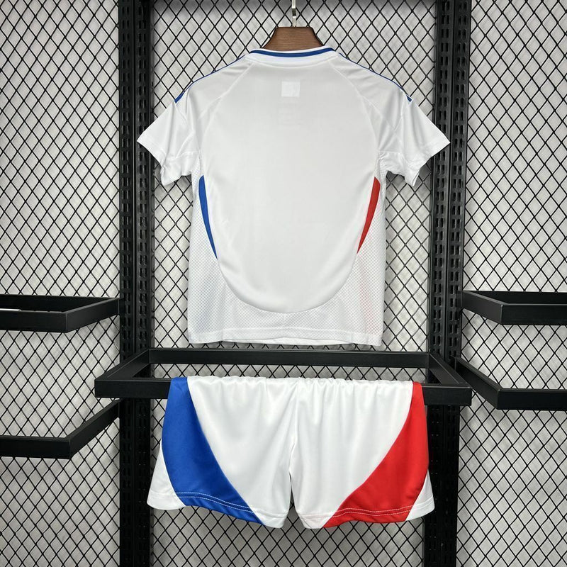 “Kit infantil Olympique Lyon 2024/25 Adidas, branco com detalhes azul e vermelho.”