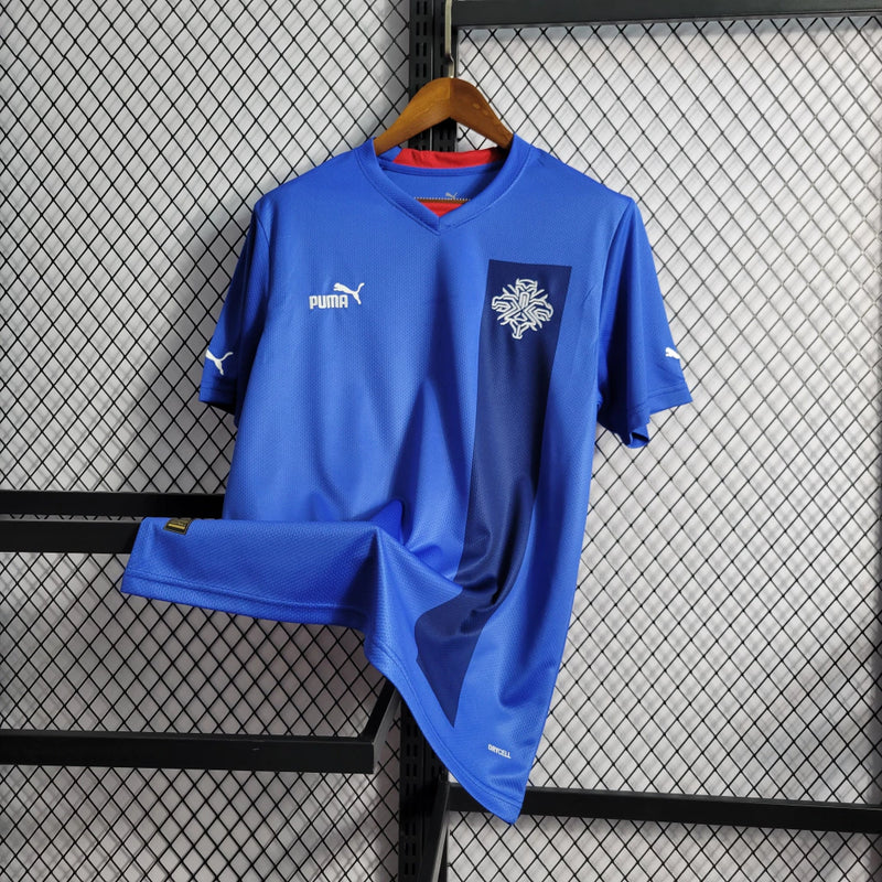 "Camisa Islândia Home I 2022/23 Puma masculina azul com detalhes em branco e vermelho, gola careca, mangas curtas e tecido leve respirável para torcedores"