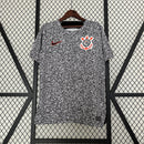 Camisa Corinthians 2023/24 Edição Especial Nike Torcedor Masculina com estampa preta e branca estilo caderno universitário, escudo bordado e logo Nike vermelho, pendurada em cabide contra uma grade metálica.