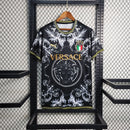 Camisa Concept Itália x Versace Puma Torcedor masculina, preta, com escudo da seleção italiana no peito, detalhes exclusivos da Versace e três listras Puma nos ombros, feita em tecido leve e respirável, modelo com caimento confortável, ideal para torcer com estilo e exclusividade.”