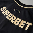 Camisa Comemorativa SPFC 2025 Masculina New Balance na cor preta com detalhes dourados, faixa tricolor no peito e escudo oficial do São Paulo Futebol Clube.