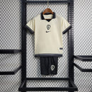 Kit Infantil Corinthians IV 2023/24 Nike, camisa preta com detalhes em branco, shorts e meias combinando, uniforme oficial do Timão para torcedores mirins."