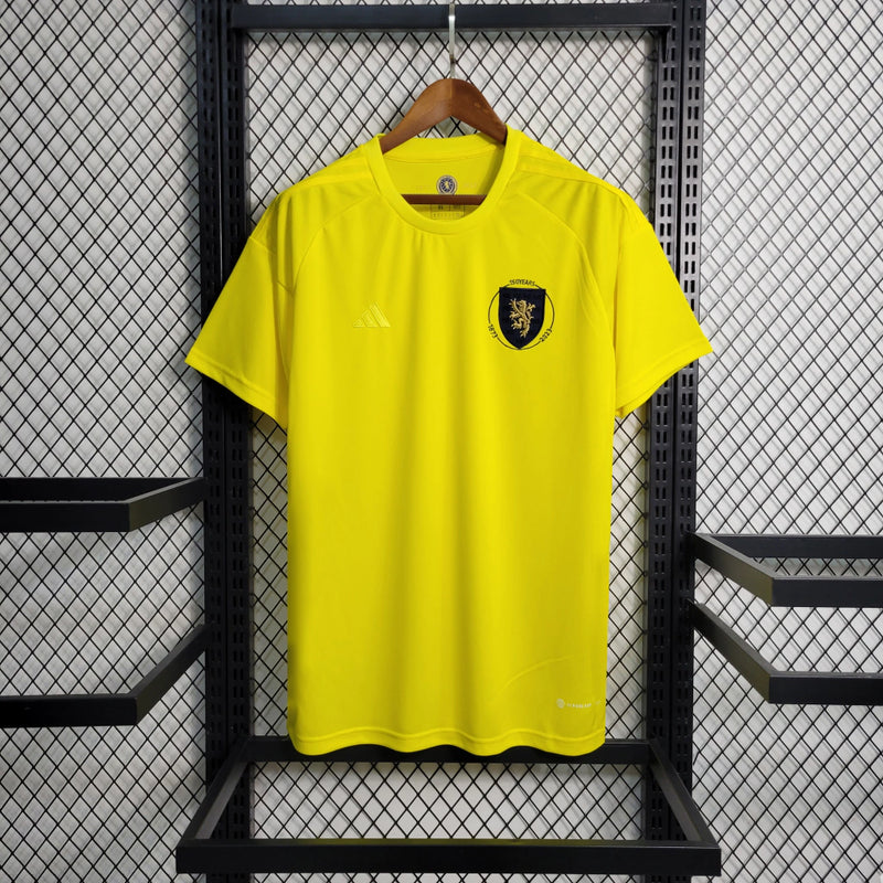Camisa Escócia 150 Anos Adidas masculina na cor amarela, com detalhes em azul e branco, gola em V, mangas curtas e tecido respirável, edição comemorativa de 150 anos da seleção escocesa, ideal para torcedores"