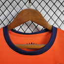 "Kit Infantil Holanda Home (1) 2024/25 Nike oficial, camisa laranja vibrante com escudo KNVB em destaque, shorts combinando, uniforme completo para crianças de 3 a 13 anos"