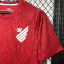 Camisa Athletico Paranaense Treino 2024/25 Umbro Torcedor Masculina com escudo oficial bordado e logo Umbro estampado, modelo masculino em tecido respirável para treino e uso casual.