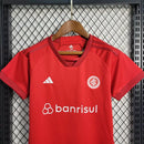 Kit Infantil Internacional Home 2022/23 Adidas, camisa vermelha com detalhes em branco, shorts e meias combinando, uniforme oficial para torcedores mirins do Internacional FC."