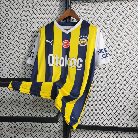 Camisa Fenerbahçe Home I 2023/24 Puma masculina em amarelo e azul, com escudo bordado e tecido respirável dryCELL, ideal para torcer e jogar futebol com conforto."