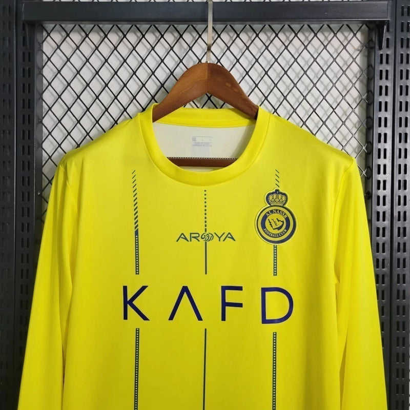 Camisa Al-Nassr Home (1) 2023/24 Nike Torcedor Manga Longa Masculina amarela com detalhes azuis, escudo oficial do Al-Nassr no peito e tecnologia Nike Dri-FIT."
