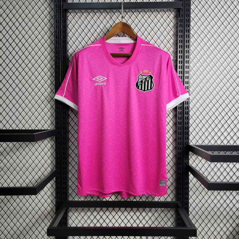 Imagem da Camisa Santos 2023/24 Umbro Torcedor Masculina na cor rosa, com escudo do Santos FC bordado no peito e detalhes em branco e preto.