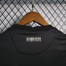 Camisa Corinthians Away 2021/22 Nike Torcedor Masculina na cor preta com listras verticais brancas, escudo bordado no peito e logo da Nike. Modelo pendurado em cabide sobre fundo metálico com grade.