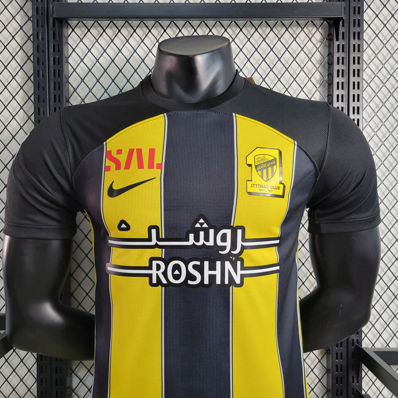 Camisa Al-Ittihad Home I 2023/24 Nike Jogador Masculina preta e amarela, modelo player com listras verticais, tecnologia Dri-FIT ADV e escudo do Al-Ittihad no peito – uniforme titular da temporada 23/24.