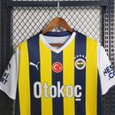 Camisa Fenerbahçe Home I 2023/24 Puma masculina em amarelo e azul, com escudo bordado e tecido respirável dryCELL, ideal para torcer e jogar futebol com conforto."