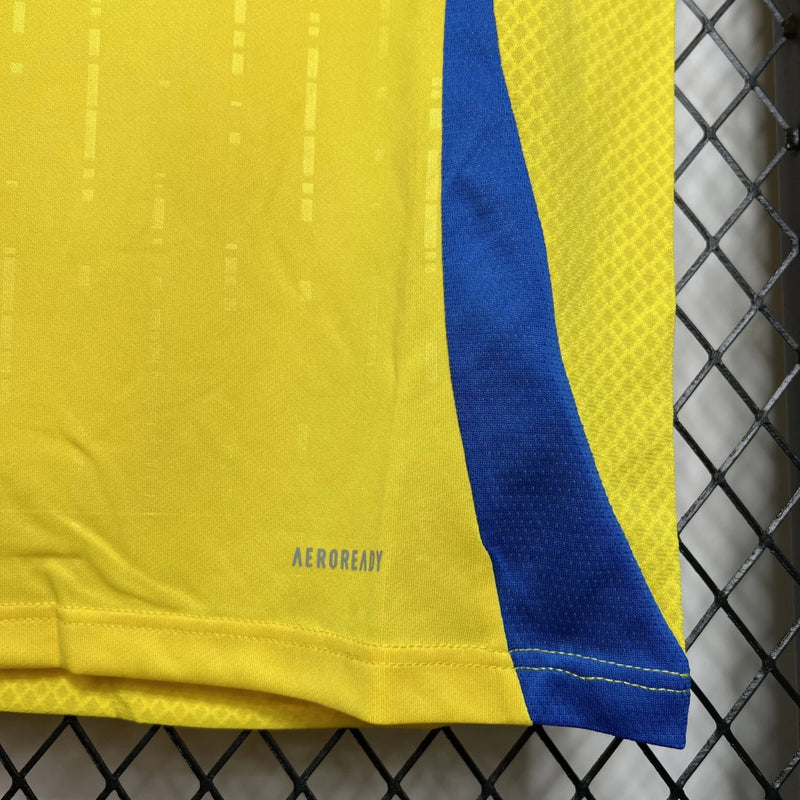 Camisa Al-Nassr Home (1) 2024/25 Adidas Torcedor Masculina na cor amarela com detalhes em azul, escudo do Al-Nassr aplicado no peito e logo Adidas bordado, modelo oficial da temporada 2024/25."

