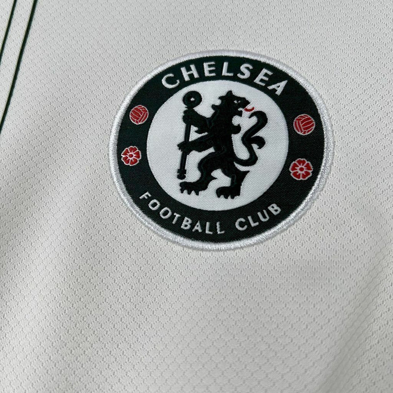 Camisa Chelsea Away 2025/26 Nike Torcedor Masculina branca, com escudo bordado do Chelsea FC, detalhes em azul royal e dourado, modelo  com tecnologia Dri-FIT e design moderno para torcedores apaixonados.