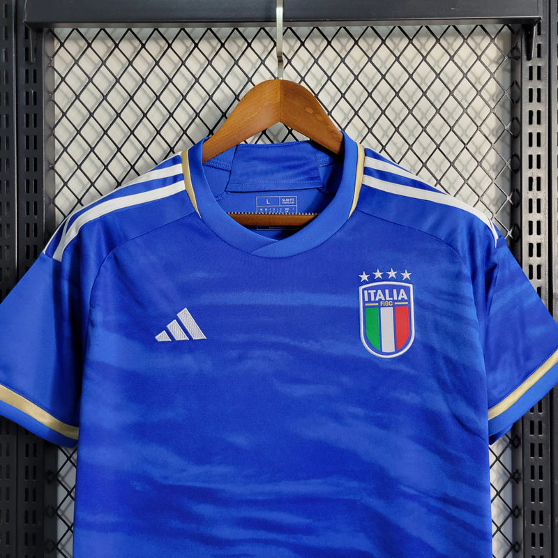 Camisa Itália Home I 2023/24 Adidas Torcedor masculina, azul, com escudo da seleção italiana no peito e três listras Adidas nos ombros, feita em tecido leve e respirável, modelo com caimento torcedor mais solto e confortável, ideal para torcer com estilo e autenticidade.”