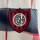 Camisa San Lorenzo Away II 2024/25 Nike Torcedor Masculina branca com detalhes em azul e vermelho, escudo estampado do clube argentino e tecido leve e respirável para torcedores."