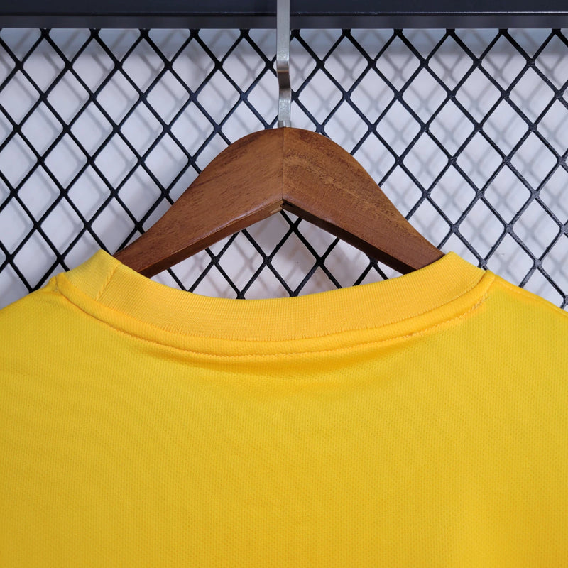 Camisa Al-Ittihad Home I 2023/24 Nike Torcedor Masculina amarela com detalhes em preto, uniforme titular do Al-Ittihad Club da Arábia Saudita, modelo torcedor com tecido leve e tecnologia Dri-FIT para absorção de suor."