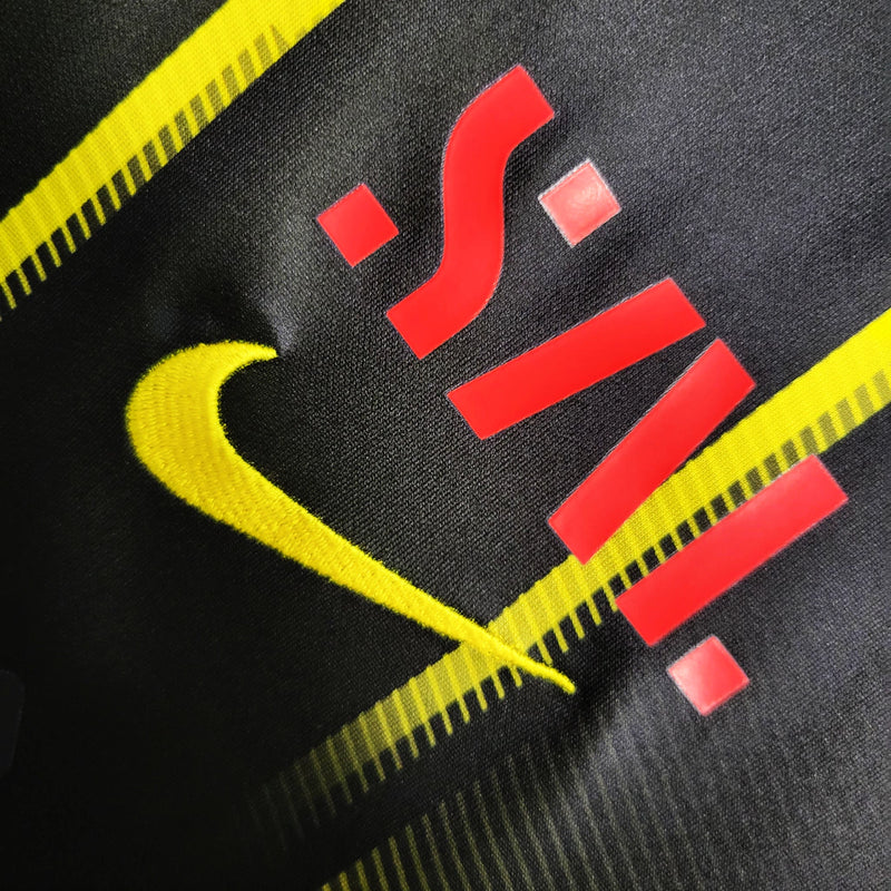 Camisa Al-Ittihad Away II 2023/24 Nike Torcedor Masculina preta, uniforme oficial do clube saudita, design moderno com detalhes amarelos, escudo em destaque e tecnologia Nike Dri-FIT para conforto e performance.