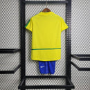 Kit Infantil Brasil Home 2002 Nike Retrô – uniforme completo com camisa amarela, shorts azul e meião branco, inspirado no penta da Copa do Mundo, confortável e ideal para crianças apaixonadas por futebol."