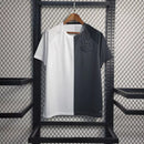 Camisa retrô Corinthians 2024 Nike nas cores preta e branca, com escudo monocromático e design dividido verticalmente, pendurada em arara de loja."
