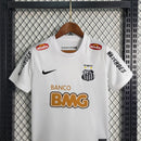 Kit Infantil Santos Home 2012/13 Nike Retrô – uniforme infantil oficial com camisa branca clássica, escudo bordado do Santos FC e short, ideal para pequenos torcedores e colecionadores.
