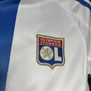 “Kit infantil Olympique Lyon 2024/25 Adidas, branco com detalhes azul e vermelho.”