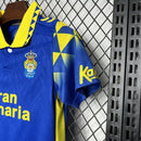Kit Infantil Las Palmas Away II 2024/25 Hummel com camisa e short, uniforme infantil azul e amarelo, tecido leve e respirável, ideal para jogos, treinos e jovens torcedores do Las Palmas."