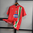 Camisa Juventus Away II 2005/06 Nike Retrô Masculina vermelha, escudo da Juventus bordado no peito, gola redonda clássica e detalhes em preto e branco.