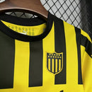 Kit Infantil Peñarol Home 2024/25 Puma - uniforme oficial infantil com camisa listrada amarela e preta e shorts, produto confortável e autêntico para pequenos torcedores do clube uruguaio