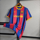 "Camisa Barcelona 2010/11 Nike Masculina, close no escudo oficial do FC Barcelona aplicado no peito, peça icônica azul e grená."
