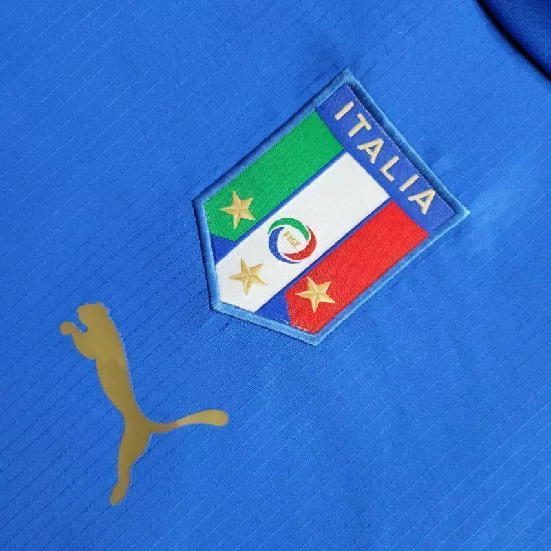 Camisa Itália Home I 2006/07 Puma Retrô Masculina, azul, com escudo da seleção italiana e logo Puma bordados, feita em tecido leve e confortável, modelo retrô masculino com caimento tradicional.”
