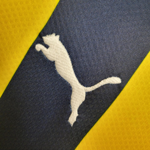 Camisa Fenerbahçe Home I 2023/24 Puma masculina em amarelo e azul, com escudo bordado e tecido respirável dryCELL, ideal para torcer e jogar futebol com conforto."