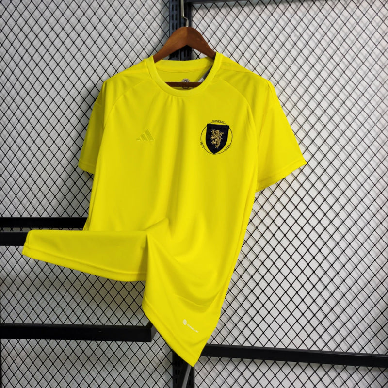 Camisa Escócia 150 Anos Adidas masculina na cor amarela, com detalhes em azul e branco, gola em V, mangas curtas e tecido respirável, edição comemorativa de 150 anos da seleção escocesa, ideal para torcedores"