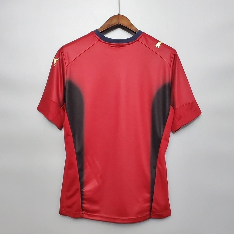 “Camisa Itália Goleiro 2006/07 Puma Retrô masculina, vermelha, com escudo da seleção italiana no peito e detalhes clássicos da temporada 2006/07, feita em tecido leve e confortável, ideal para colecionadores, fãs de futebol histórico e uso casual.”