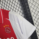 "Camisa Ajax Home (1) 2024/25 Adidas Torcedor Masculina oficial, branca com faixa vermelha central, escudo bordado e logo Adidas, versão torcedor da temporada 24/25."