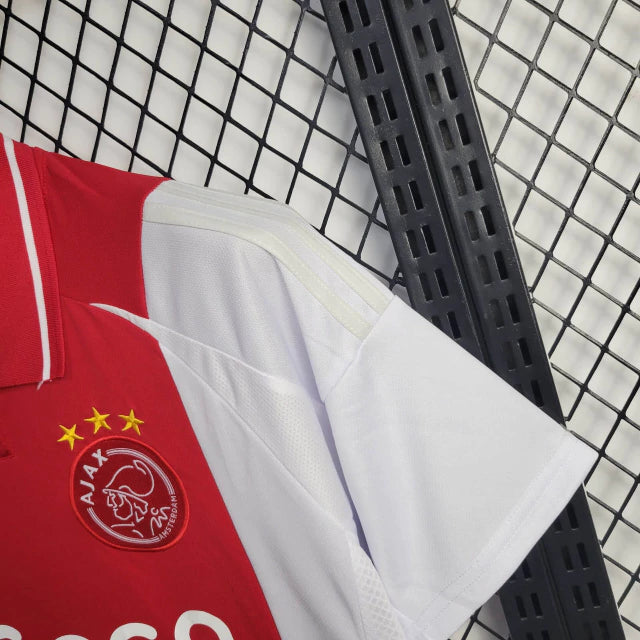 "Camisa Ajax Home (1) 2024/25 Adidas Torcedor Masculina oficial, branca com faixa vermelha central, escudo bordado e logo Adidas, versão torcedor da temporada 24/25."